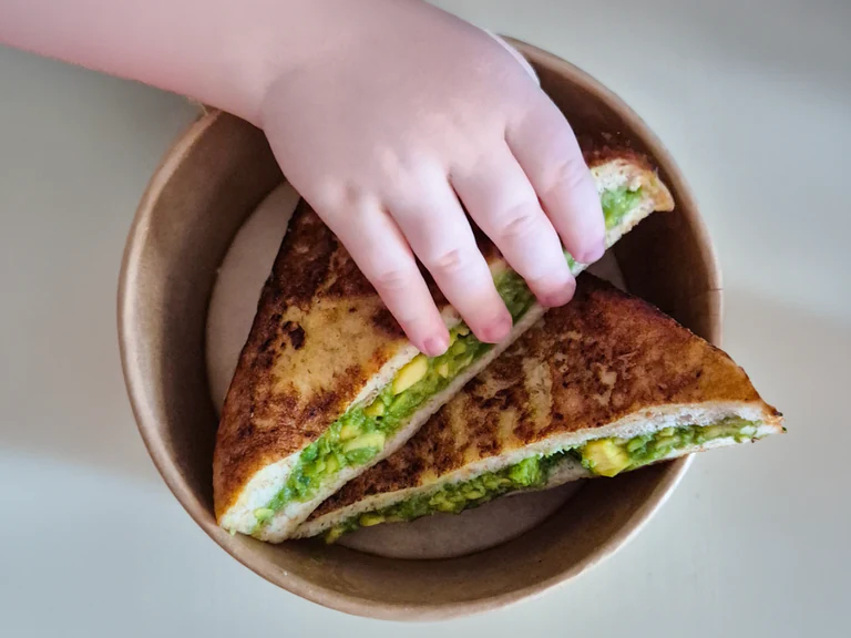 A child reaching for a healthy sandwich at Network School