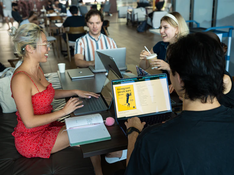 Network School members working together around a table